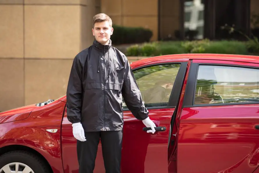 A man standing next to red car